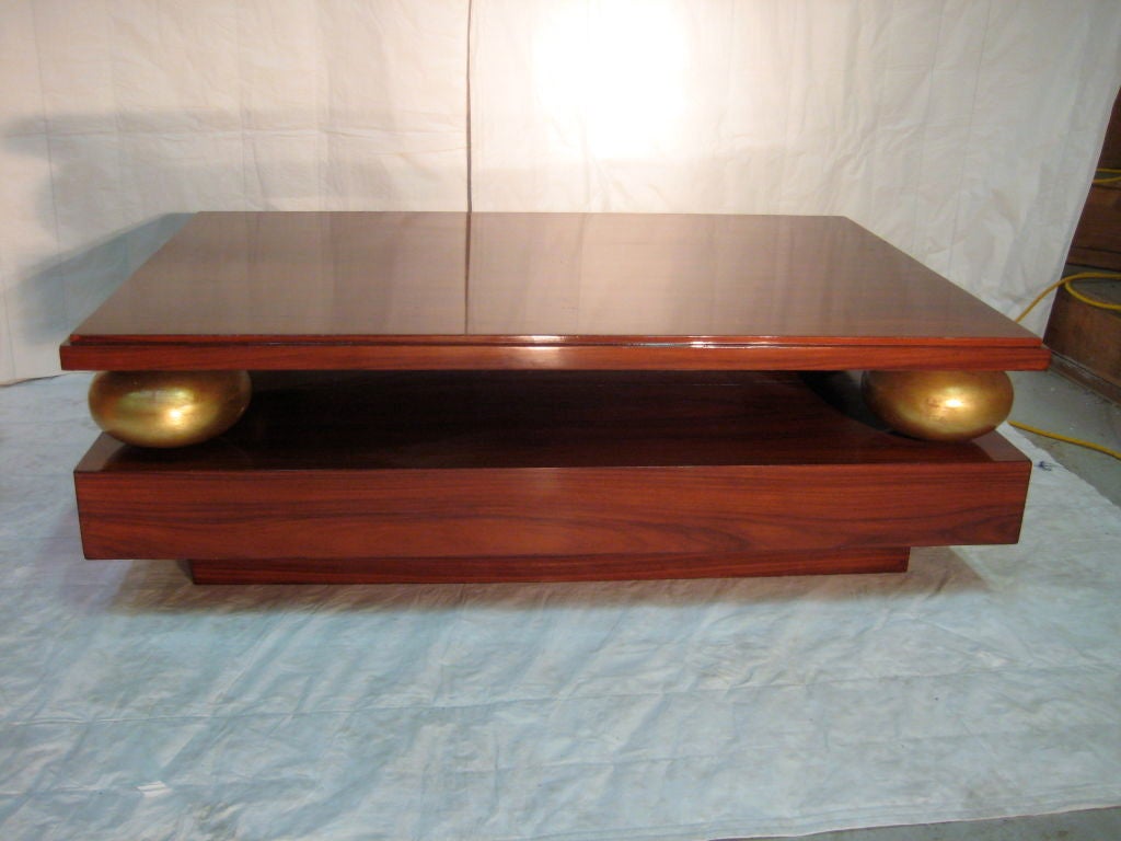 A French Art Deco coffee table in the moderne style<br />
in rosewood with gilded sphere detail.