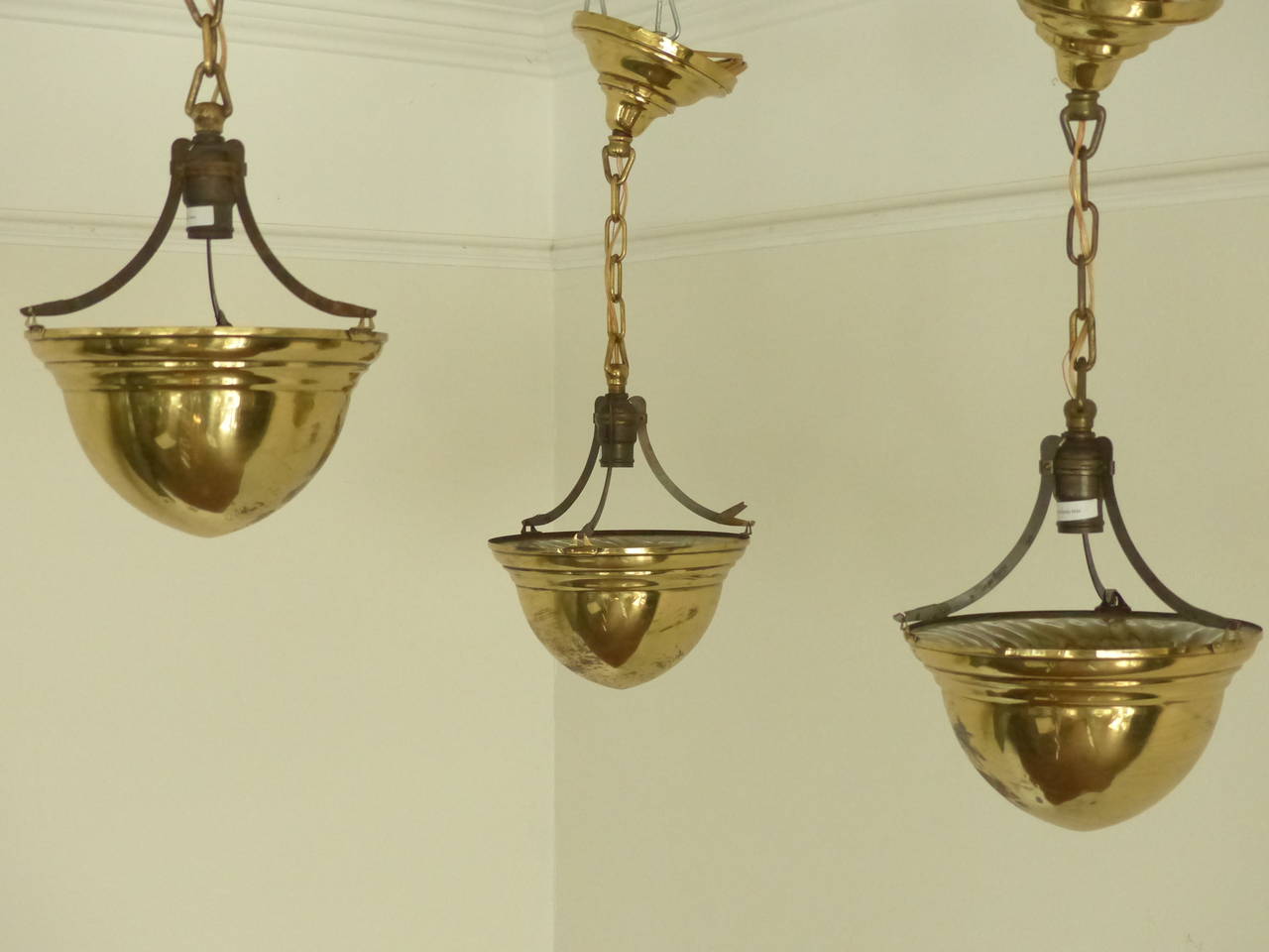 Set of three, circa 1920 pendant lights in solid brass. Each includes their original chain and ceiling mount. Found in Chicago. Re-wired and CSA approved.