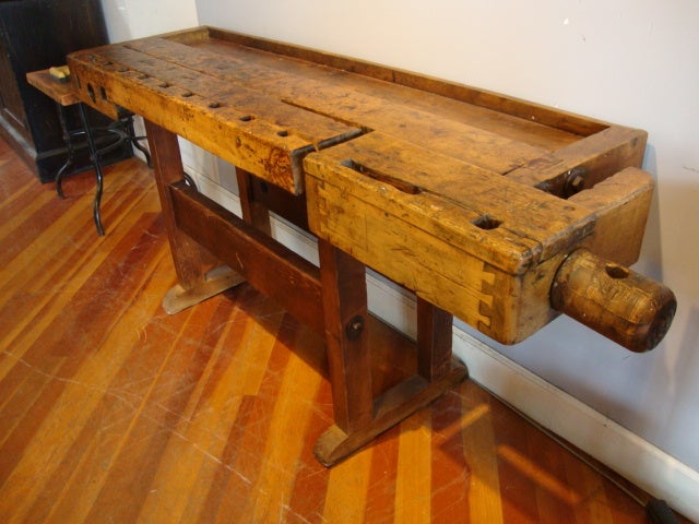 Narrow maple workbench from Quebec, with large vise on end and heavy patina surface