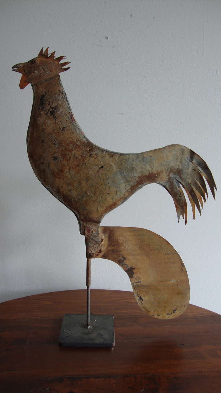 Pressed tin rooster weather vane with traces of original paint . Feathers embossed on side with bottom wind catcher.