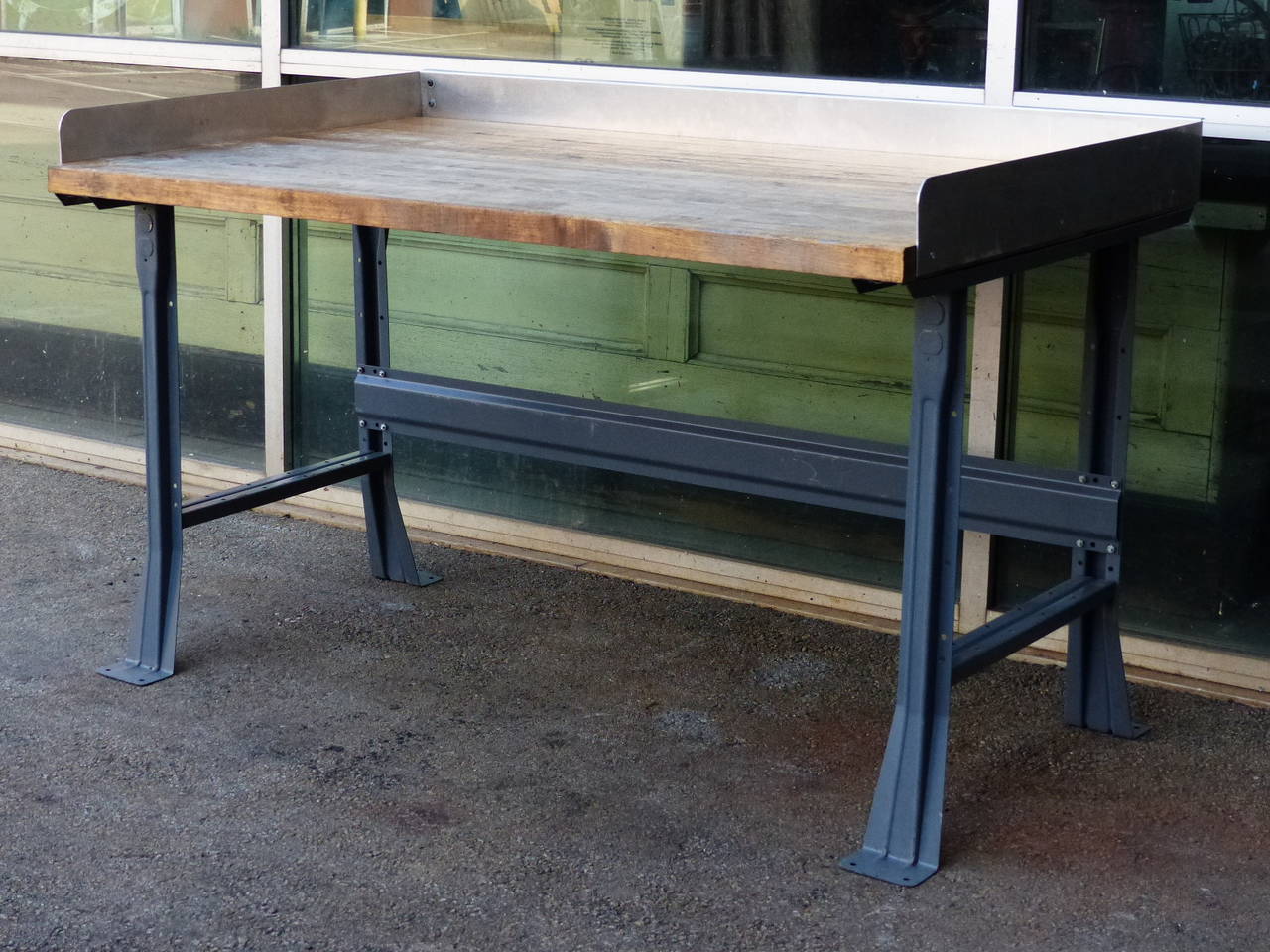 Steel industrial work table with maple top and 3/4 aluminum surround back splash.