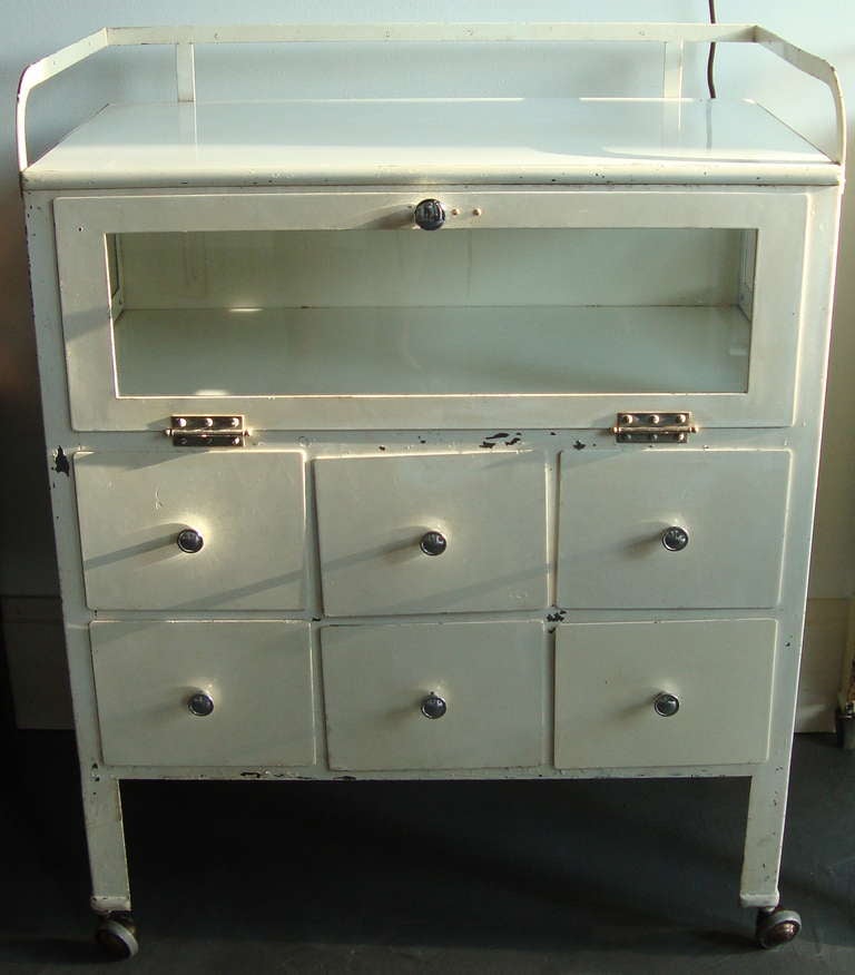 Smaller medical cabinet with clear glass door and 4 metal drawers for storage. Original surface paint, in untouched condition