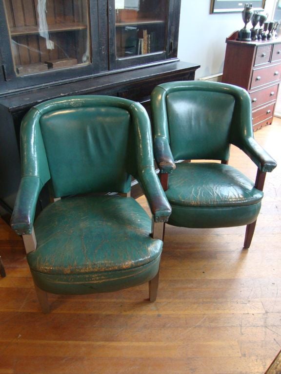 Pair of green leather chairs with great aged wear on arms. Found in Toronto