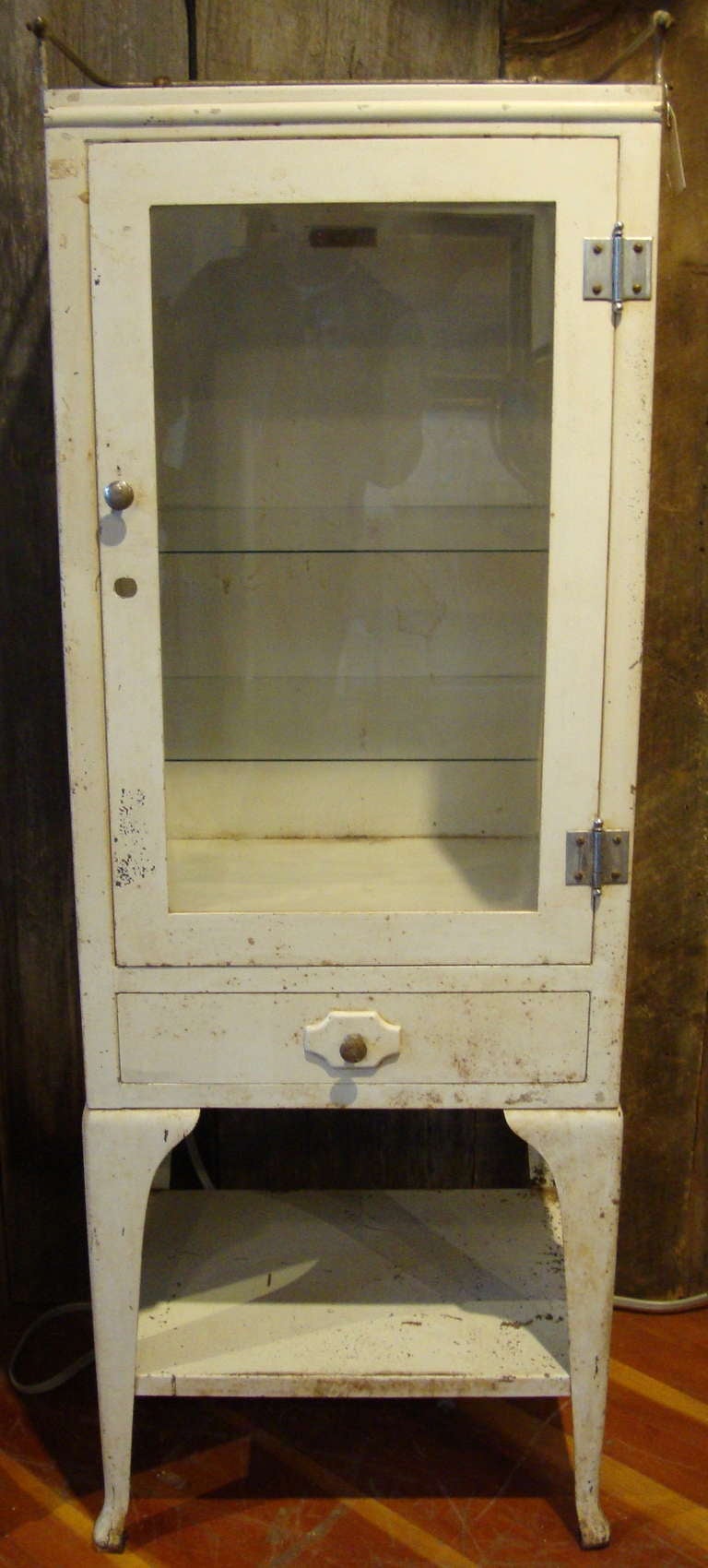Steel medical cabinet in original paint, untouched condition with top galley and bottom drawer.