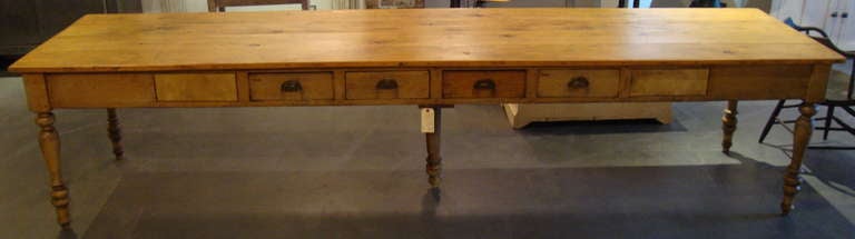 Unique and rare convent table with multiple drawers on both sides, in an old refinished patina. Found in Quebec