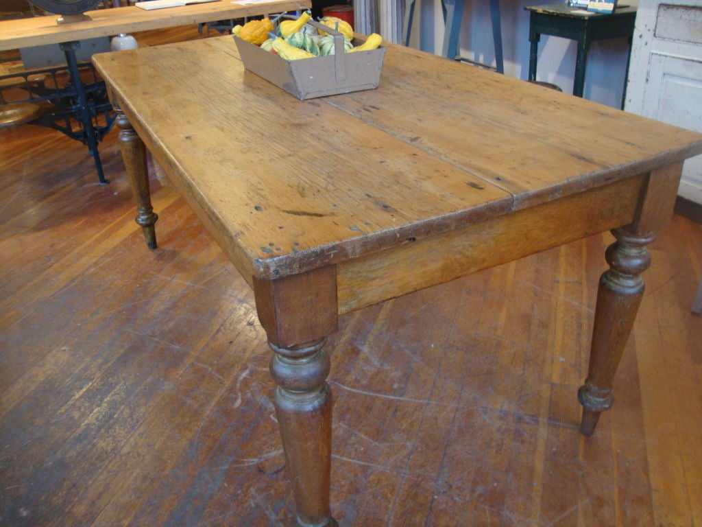 Original pine two board top harvest table with bold turned leg with strong patina. This piece is in old refinished condition, recently acquired from a private collection.