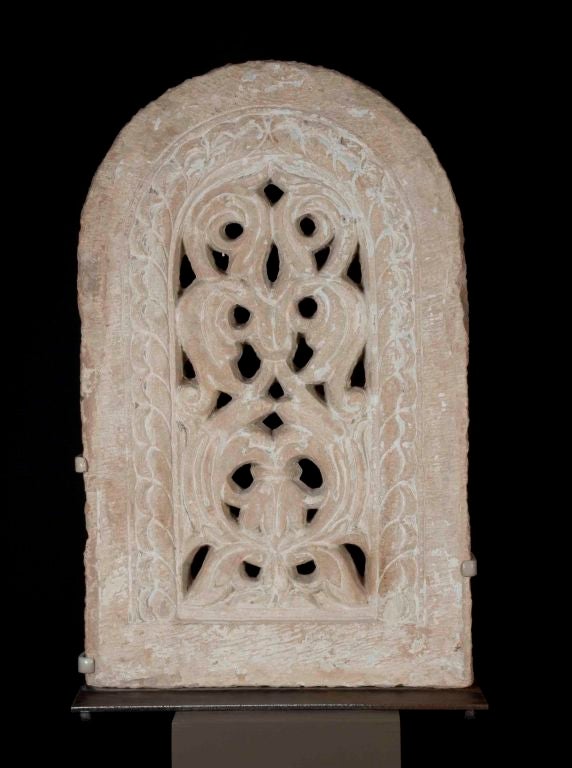 A solid sand-stone carved window from an 18th century Indian temple or palace mounted as a sculpture on a custom metal art stand.  Remains of period overpaint add to the character of the sculpture.  Could be used in an interior or garden setting. 