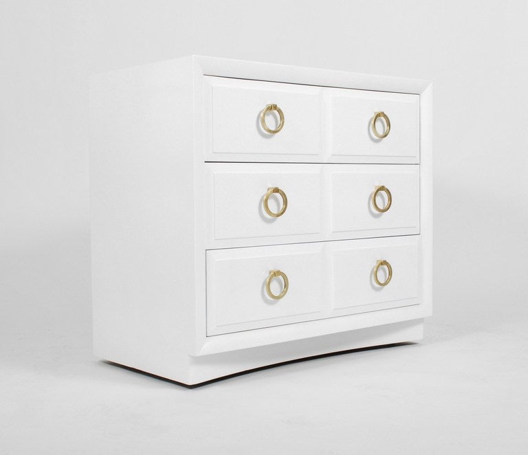 Elegant three (3) drawer dresser designed by T. H. Robsjohn Gibbings for Widdicomb. This dresser has been beautifully refinished in glossy white lacquer accented by the handsome original matte brass drawer pulls. Each drawer has beveled fronts over