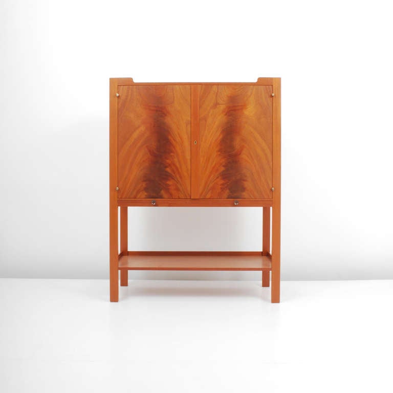 Finely crafted cabinet/secretary with two doors opening to reveal two adjustable shelves, a lower shelf, and a pull-out shelf by Josef Frank for Svenskt Tenn, Sweden. Beautiful book matched mahogany burl wood on the front and sides crafted in a