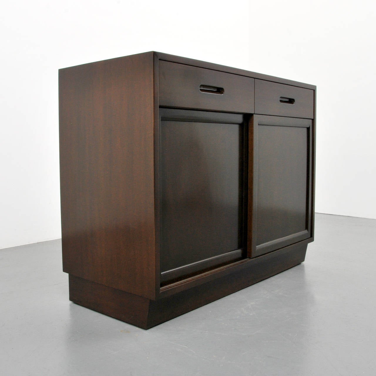 Cabinet/server/buffet is a variation of model 5668 and features a finished back, two drawers with separators, two doors each revealing three pull-out shelves and storage. Reference (similar form): Dunbar fine furniture of the 1950s, preface by