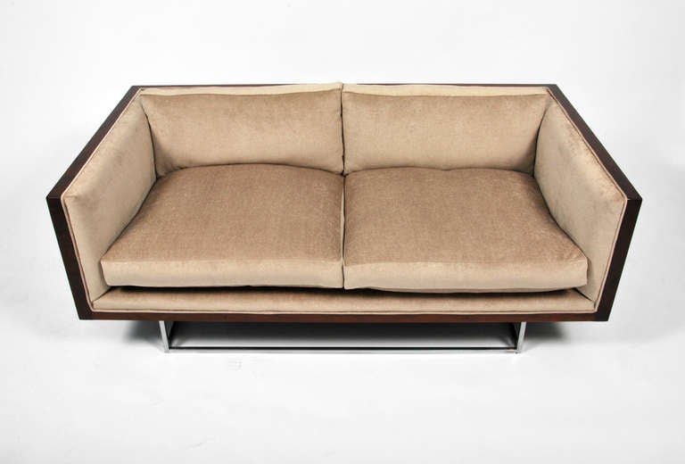 Beautifully designed and crafted rosewood case settee with a distinctive, elevated polished chrome base by Milo Baughman for Thayer Coggin. This streamlined modernist sofa design has been newly upholstered in a luxurious light beige Scalamandre
