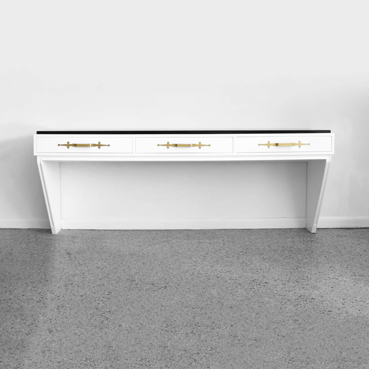 Lacquered wall-mounted console table with black marble top and brass drawer handles designed by Tommi Parzinger for Parzinger Originals. Signed with branded manufacturer's mark to drawer. Tommi Parzinger was the designer for the home of Jean and