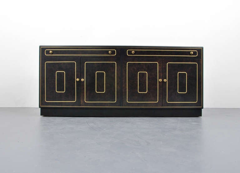 DESIGNER & MANUFACTURER: Romweber Furniture Co.

MARKINGS: marked

COUNTRY OF ORIGIN & MATERIALS: USA; walnut, brass

ADDITIONAL INFORMATION: Circassian walnut cabinet with two pair of doors each revealing a fixed shelf, two drawers, and brass