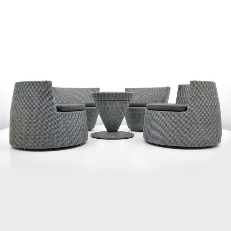 Beautifully designed and crafted five (5) piece outdoor furniture suite consisting of four (4) comfortable lounge chairs with cushions and one (1) cocktail table by Frank Ligthart for Dedon. All of the components stack together to form a space