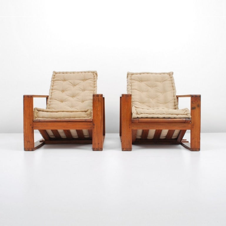 Pair of lounge chairs attributed to Jean Royere. Beautifully designed and crafted chairs upholstered with very comfortable Belgian linen seat and back cushions. The adjustable wood frame has a wonderful aged patina that gives the distinctive