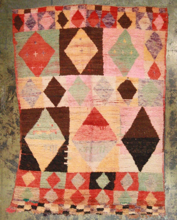 Vintage Moroccan rug with medium in center to a soft thicker pile towards edges. The diamonds are vividly colored in terra cotta, red, browns, deep browns, celedon, pink and lavender.