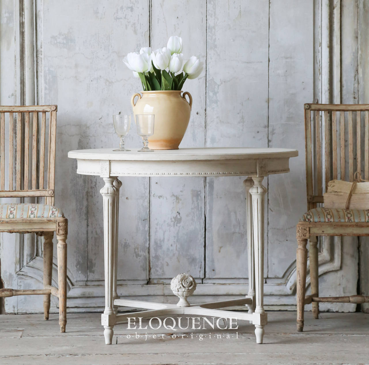 Delightful Swedish antique occasional table finished in a lovely eggshell finish. The stretcher is topped by a beautiful bouquet carving and the fluted Louis XVI style legs rise delicately to the round table top.