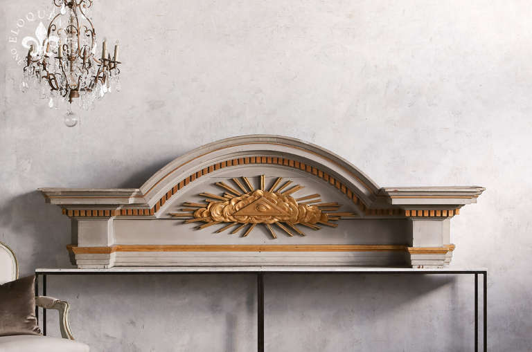 Amazing and large Antique architectural element from an entryway in France. In it's original French grey paint finish with gold leaf highlights along the hand-carved Eye of Providence and accented detail.  This piece would make a stunning way to