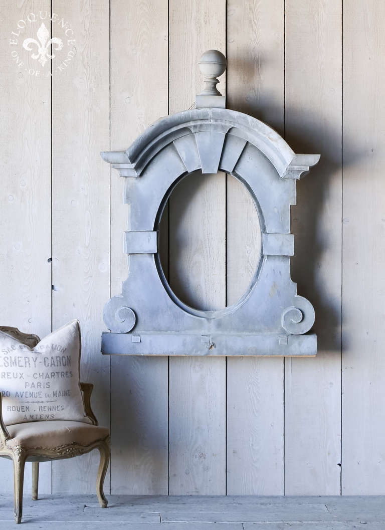 This gorgeous antique zinc dormer window is finished in a barely distressed soft patina.  The details are large and deep to add dramatic shadow, enhancing the piece's enchantment.  This would look excellent as a mirror or left alone as wall art and