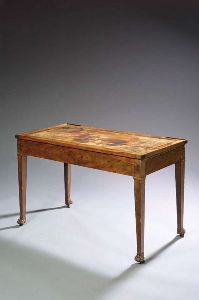 A FRENCH FIRST EMPIRE PERIOD MAHOGANY TRIC/TRAC [BACKGAMMON ] GAMES TABLE. THE REVERSIBLE TOP WITH OLD LEATHER WRITING SURFACE TO ONE SIDE WITH BAIZE TO THE REVERSE,A DRAWER TO EACH END [ONE RELINED] THE TAPERED LEGS TERMINATING IN PAW FEET. & THE