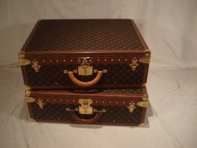 Pair of Louis Vuitton hardside luggage having special order snap up interior trays with clothes dividers and wood Louis Vuitton hangers. L/V momogram exterior with leather trim and brass findings. One with lock# 1012929 with keys, the other with
