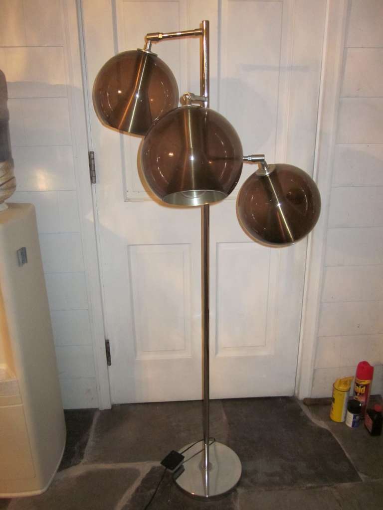 Great mid-century 3 light floor lamp.  Base, shaft and arms are chrome, with 3 brown-tinted glass globes.  Each arm is adjustable and contains a conical shaped lighting element.  Pedal off-on control.