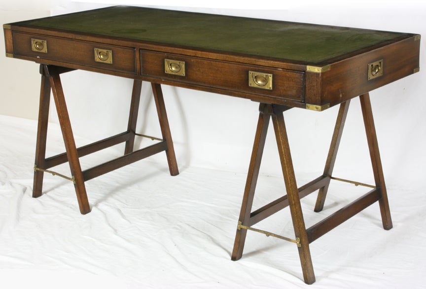 Campaign Style Desk and Chair, mahogany case fitted with green tooled leather top.  2 frieze drawers inset with brass pulls and brass corner brackets. Set on faux collapsible saw horse style bases.  Matching directors style chair with green leather