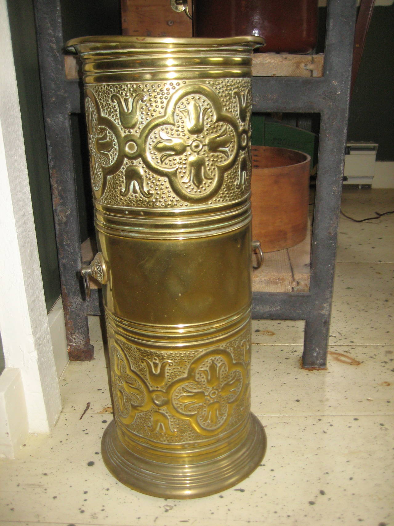 English brass umbrella stand with ornate design.