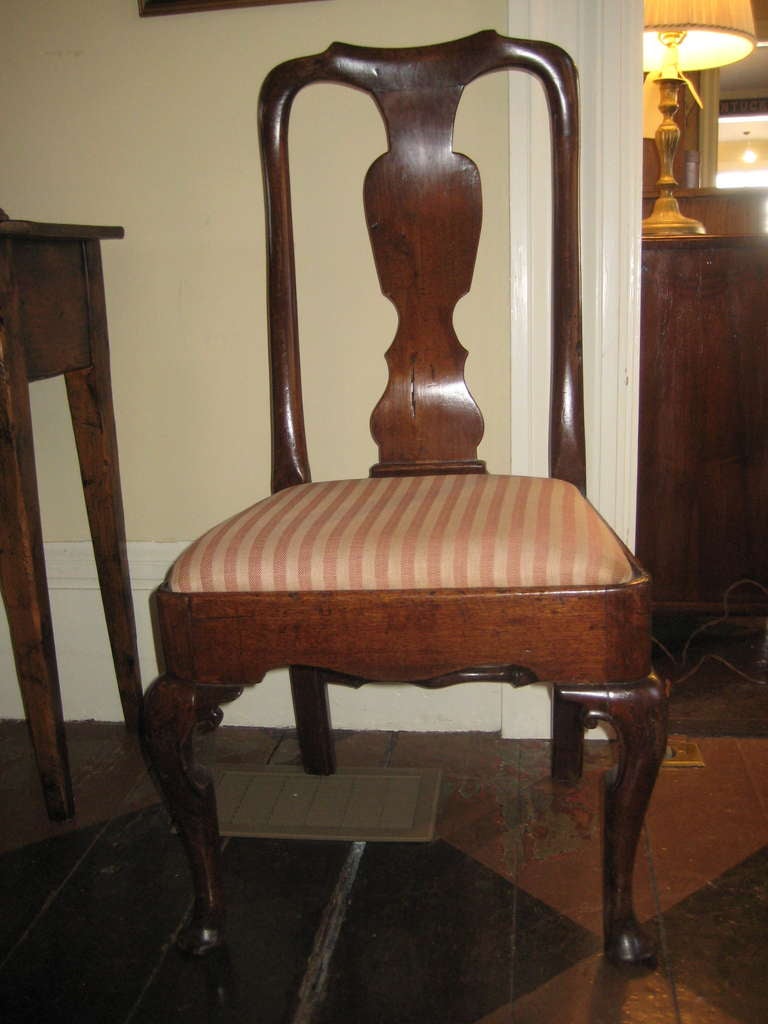 English walnut side chair with upholstered seat and cabriole front legs and carved seat rail.