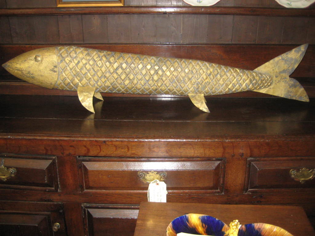 Gilded fish sculpture on stand with rosehead nails to connect the tail.  Fins and tail are metal.The stand may be mounted to the wall. The stand is not seen in picture.