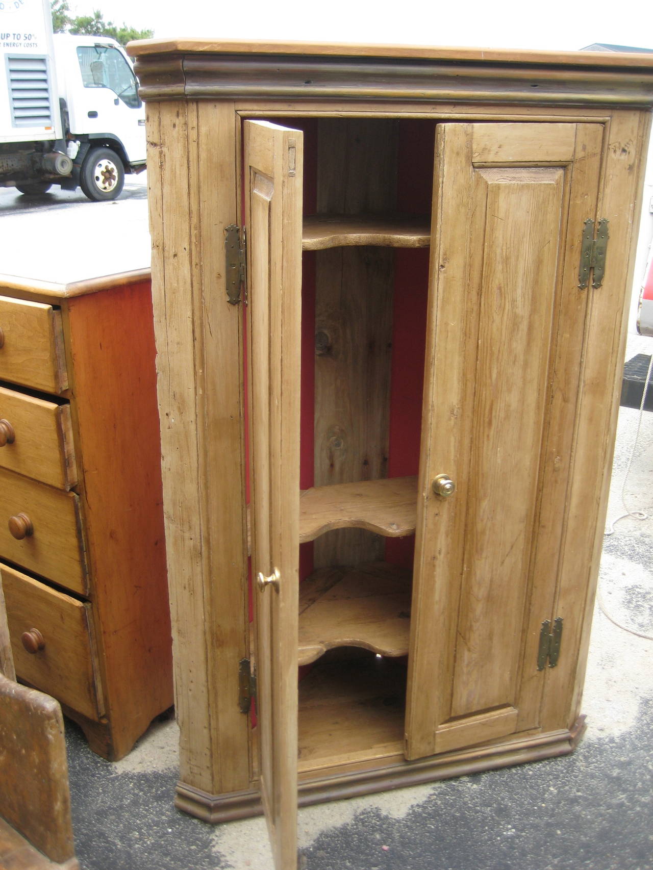 Tall Pine corner cupboard with scalloped shelves and interior red paint.