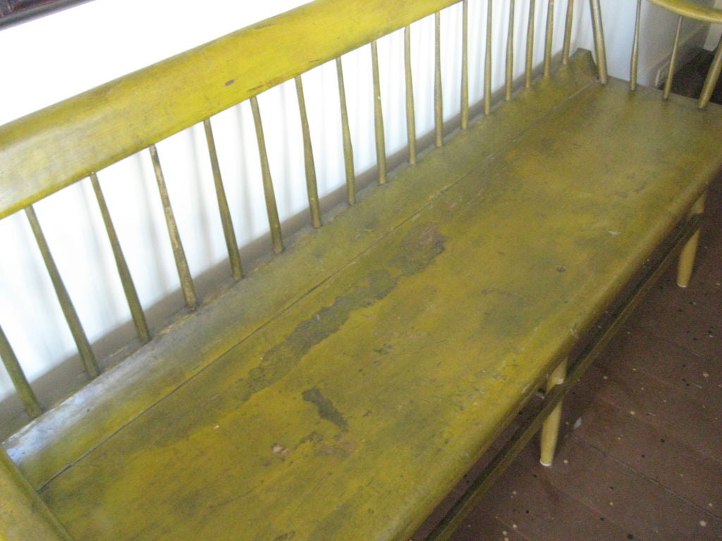 six foot windsor bench in original yellow paint; nicely shaped arms and seat; legs restored