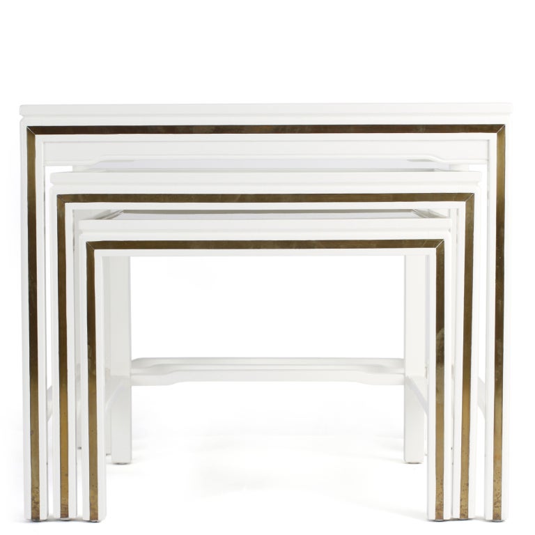 Set of three white lacquered nesting tables with brass inlay with glass tops by John Widdicomb. These tables have wonderful scale.

Table #1: 28