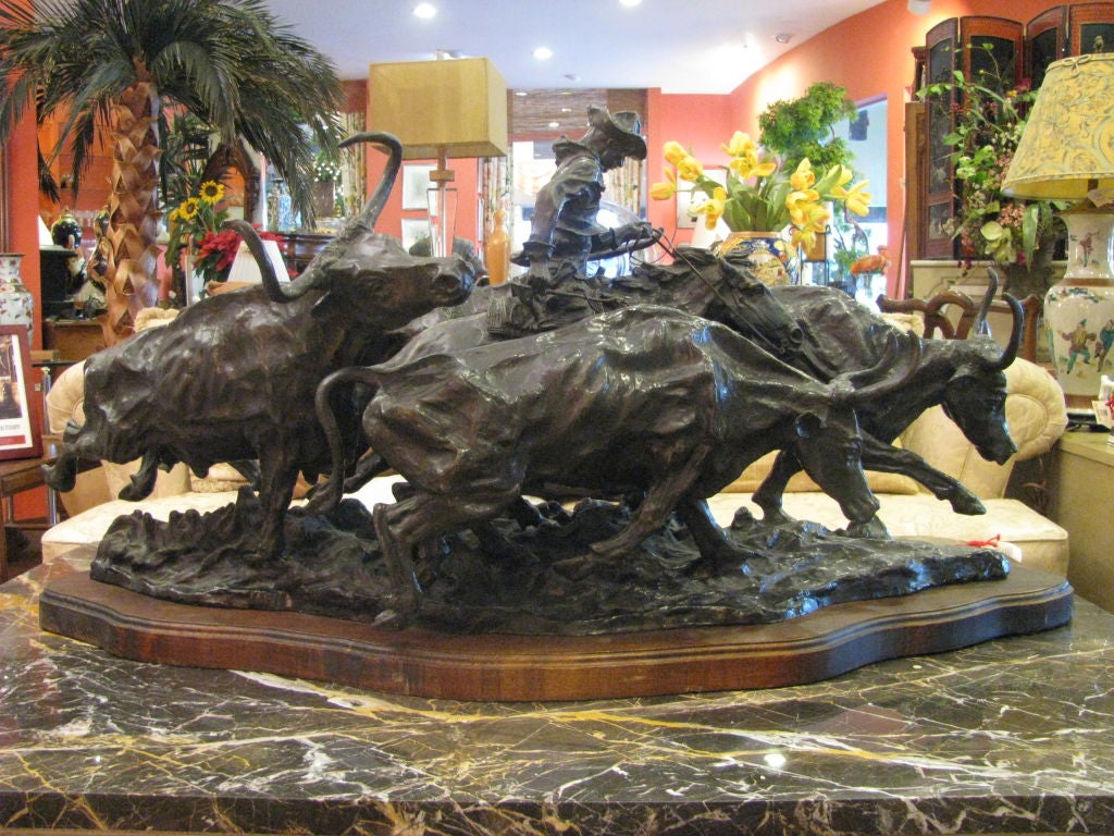 Large Remington Style Bronze Sculpture on Wood Base depicting Cowboy surrounded by 4 stampeding steers.