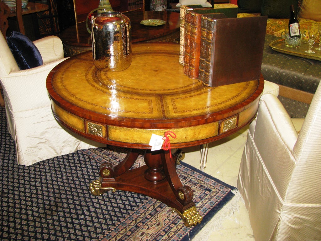 Maitland-Smith, Round, leather top accent table, with brass claw feet. Tooled leather top is trimmed with gold border.
3 drawers, matching leather side panels.