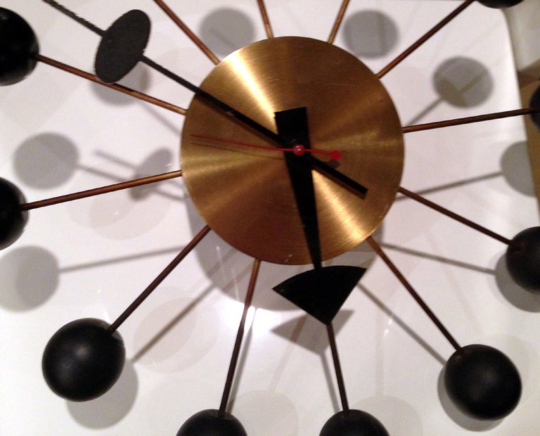 A nice ball wall clock designed by George Nelson for Herman Miller. Black lacquered ball on brass spokes and body. Plug in mechanism and it still retains the original sticker.