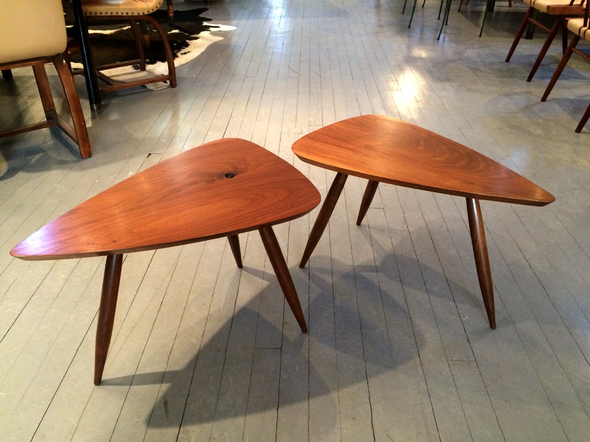 A near pair of sculpted tripod triangular tables in American Walnut studio crafted by Phil Powell in his New Hope Studio.
The table tops are supported by spindle and tapered legs and display natural sap hole and grains. Rounded edges exhibit a
