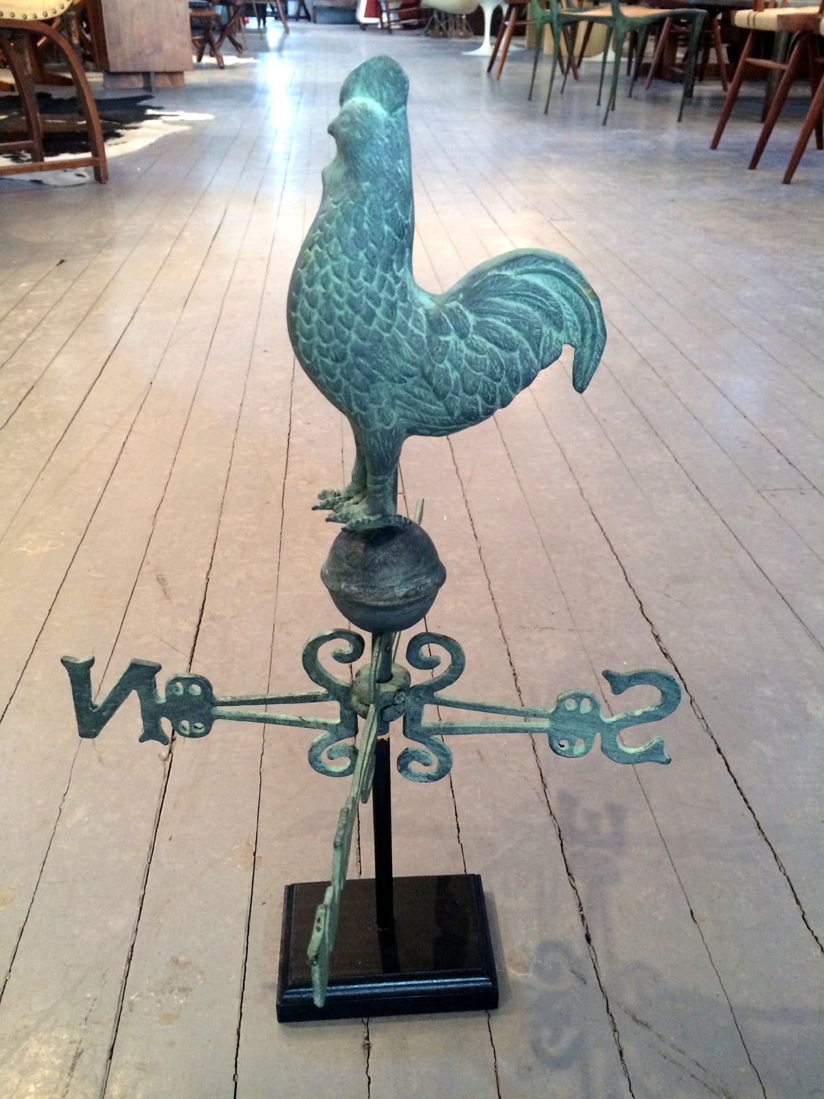 An antique rooster weathervane with complete directional arrows on a wood stand display from late 19th to early 20th century. Hudson valley area. Constructed with copper in three dimensional with detailed featured body, this piece displayed heavy