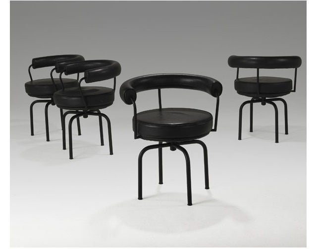 A set of four LC7 chairs designed by Le Corbusier. Manufactured by Cassina Italia. Great vintage pieces from 1970s. Black enamel steel tube structures with black leather upholstery. Can be swiveled 360 degree. Labeled with Cassina and still have its