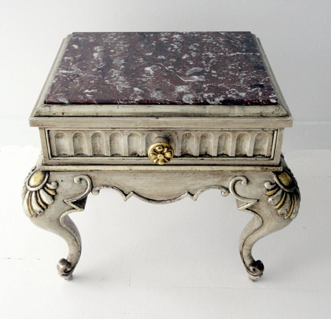 Stunning side table by Maison Jansen from France. In a Classic Rococo revival Louis XV style with carved wood and marble top, finished in an antique cerused and lacquered manner and highlighted with gilt. One drawer with a gilt carved floral pull.