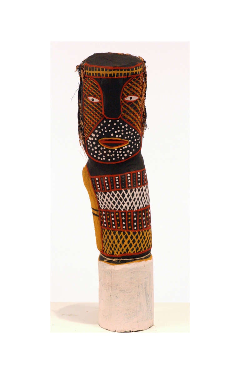 Collectée sur l'île de Tiwi, au large de la côte nord de l'Australie, cette sculpture de figure Bima a été sculptée et peinte par Myra Ann Tipiloura dans du bois de fer. Elle a été peinte à l'ocre selon le motif du clan et décorée de fibres de noix