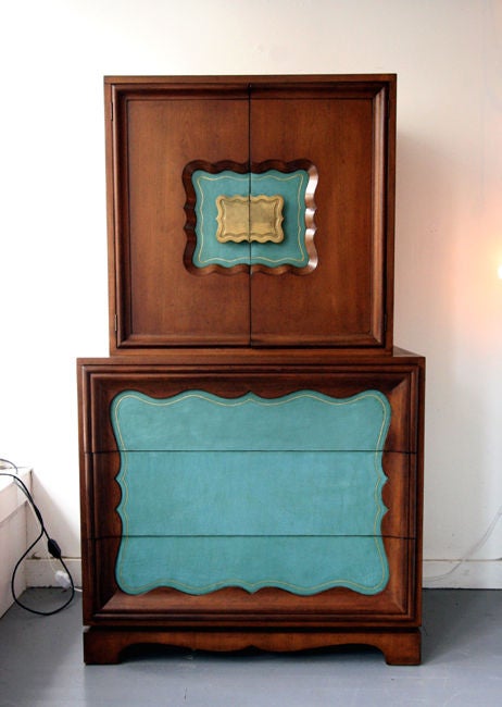 A one piece dramatic tall dresser or chest of drawers by Grosfeld House. Its skyscraper shape resonates with an aesthetic that is prevalent in art deco and but also reflects a transitional modernism. The upper part features a double door with a