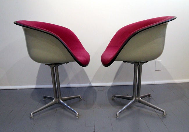 An original pair of la fonda chairs designed by Charles Eames for Herman Miller. Plum purple wool upholstery on fiber glass shell supported by cast aluminum double rod base.