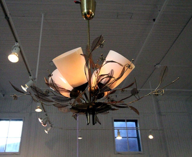 Stunning mid century chandelier by Finnish Designer Paavo Tynell. Brass construction and free form floral and branch ornaments cluster four four frosted glass shade in the center. Signed with impressed manufacturer's mark to fixture: OY Taito AB