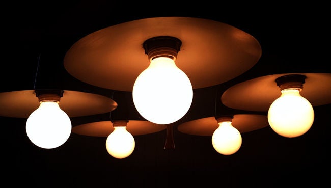 A five lights mid-century chandelier designed by Gerald Thurston for Lightolier. Brass ceiling cap, hanging rod and five downward shades contrast a central walnut long finial. Great lighting with a strong industrial vibe.