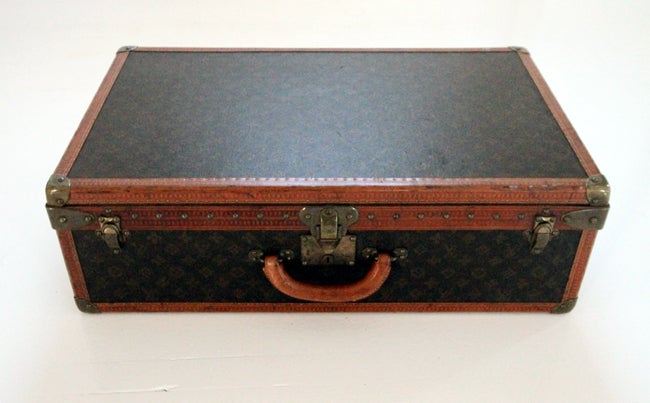 A very beautiful and well preserved Louis Vuitton hard sided suit case. Monogrammed canvas with leather trims and brass hardware. Retains interior compartmentalized linen tray and two original stickers showing the series number and the
