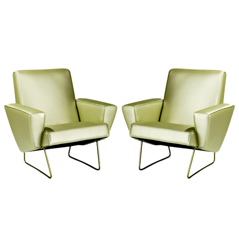 A pair of French vintage club chairs designed by Pierre Guariche. Supported by simple yet elegant metal legs, the chairs have Guariche's signature strong geometrical lines and appear floating in the air. Great architectural forms from different