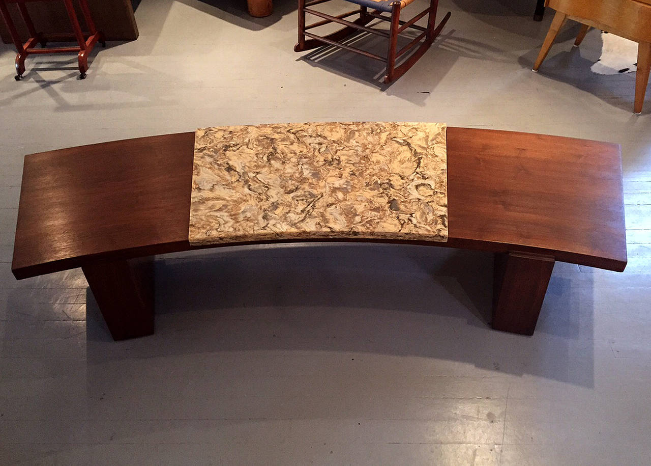 An early and rare model of curvy coffee table by Vladimir Kagan for
Kagan-Dreyfuss, Inc., circa 1950. Constructed from walnut and inset with a piece of beautifully grained marble. This design has an earthy and Zen aesthetic with its low and
