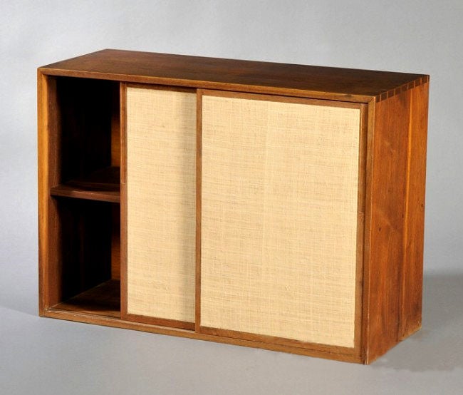 Walnut cabinet constructed in rectangular form with dovetail joints. Fitted with sliding doors covered with grass cloth. Commissioned by a couple for their wedding in 1947 and handcrafted by Nakashima in New Hope, Pennsylvania.
Please call before