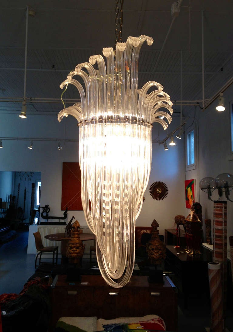 A very large and bespoken chandelier likely from 1960s or earlier in the style of Art Deco. Chrome frame with lucite ribbons creating quite an architectural cascading form. A glamorous 